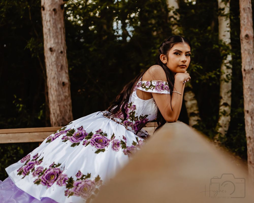 Purple and white floral ballgown photographed in a forest setting.