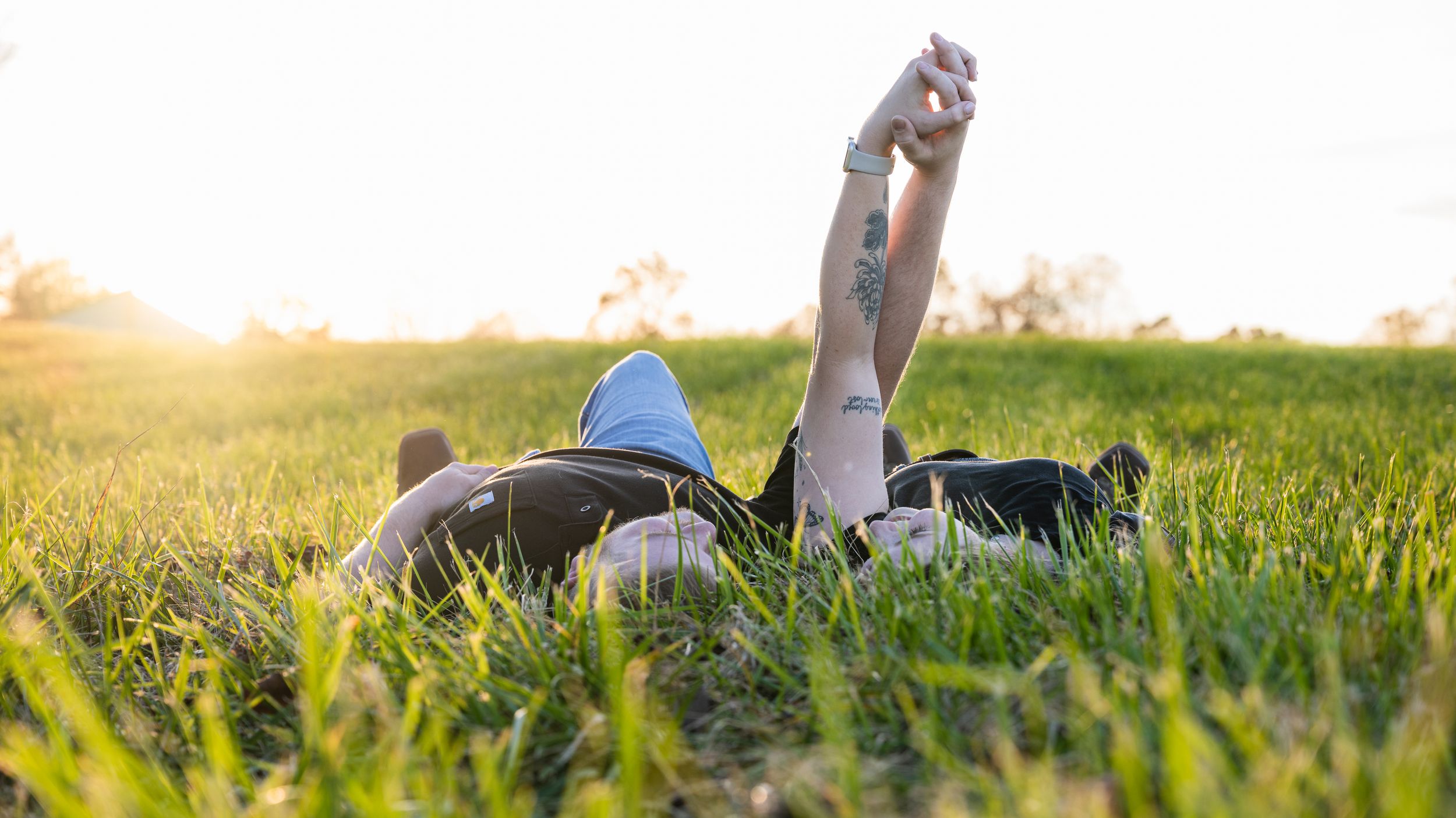 A romantic sunset engagement photoshoot in a golden field with soft sunlight filtering through.