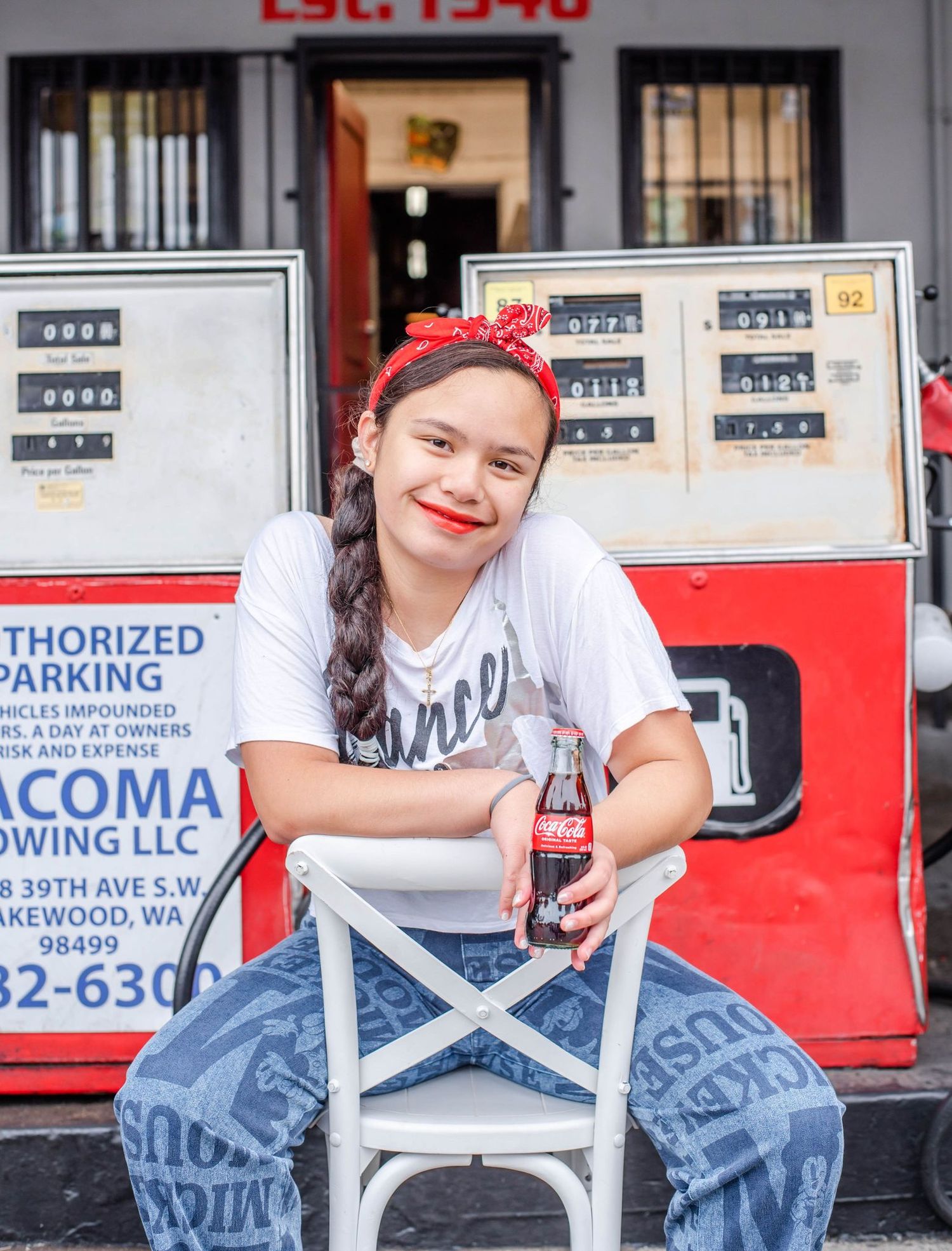 Casual photo session in front of a retro gas station with denim overalls and red bandana.
