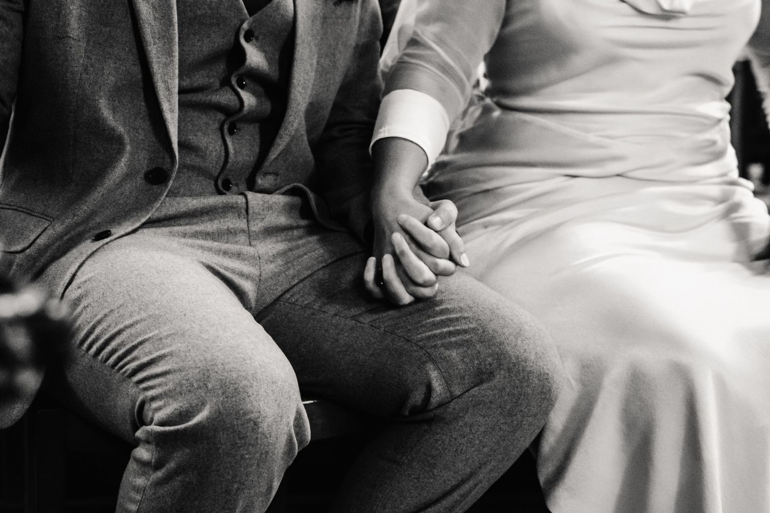 A wedding couple hold hands at Upwey Church, Weymouth Dorset.. Documentary candid  Wedding Photographer, Dorset Somerset, Devon