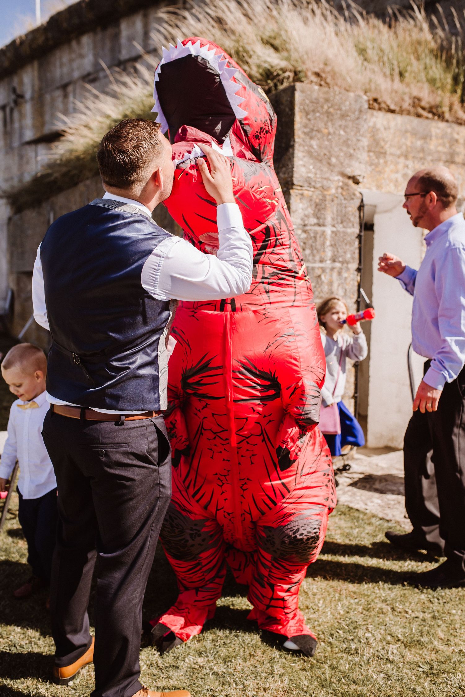 Bride in inflatable dinosaur costume at Nothe Fort, wedding. Documentary candid  Wedding Photographer, Dorset Somerset, Devon, hampshire