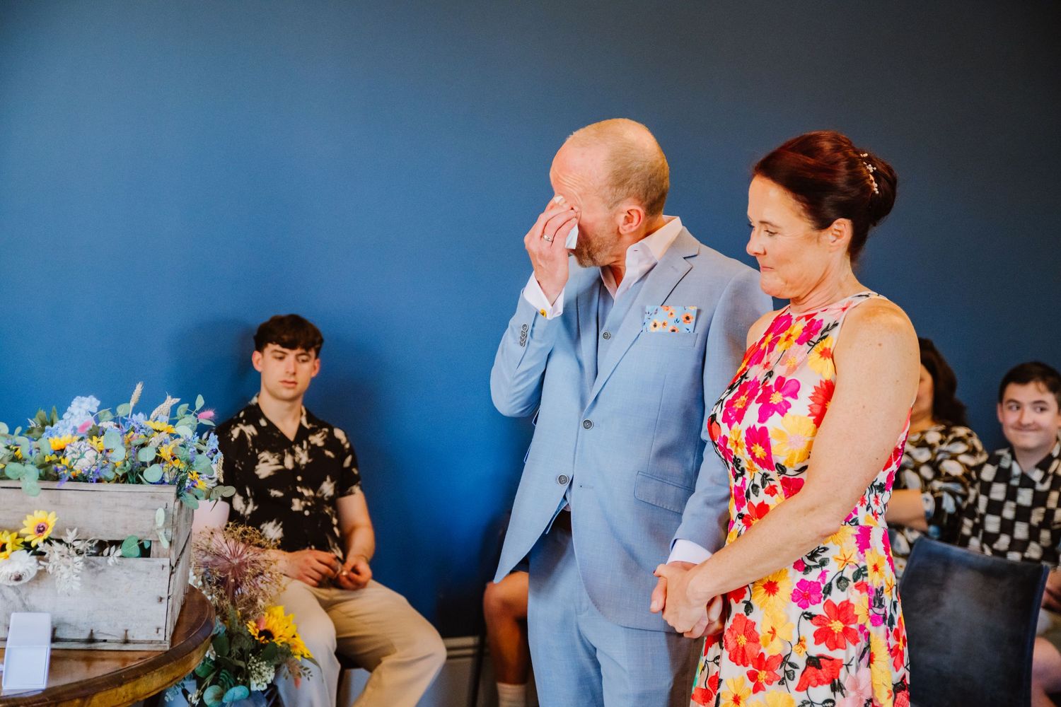 Emotional groom at Winchester Registry office. Bride in bright flowery dress from Etsy.
