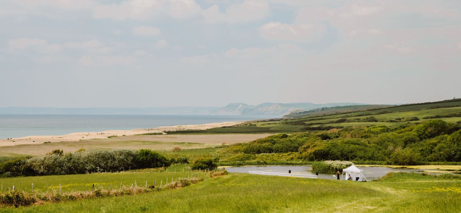 Outdoor wedding Dorset overlooking chesil beach and Bridport. Bridport wedding. Chesil beach. Celebrant wedding Dorset.