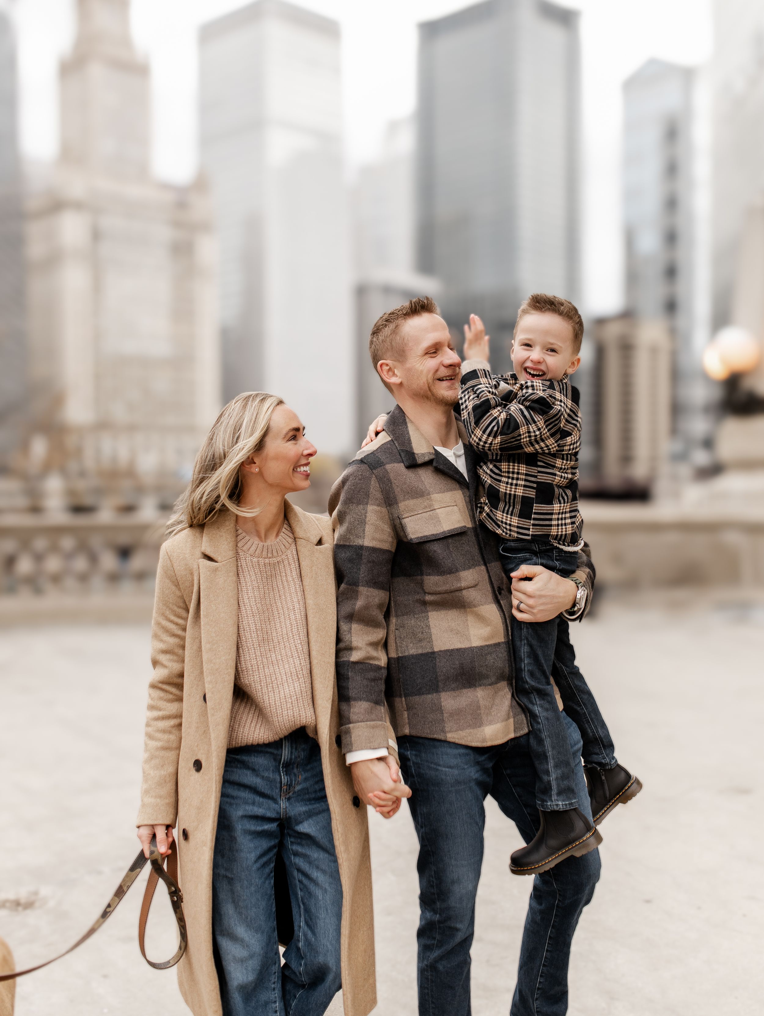 Family enjoying a casual stroll along Chicago River with downtown buildings in background.