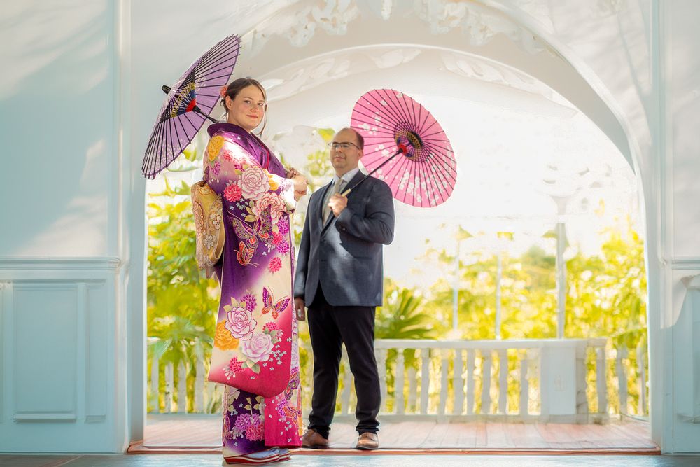 Braut in Kimono inspiriertem Kleid und Bräutigam posieren liebevoll – moderne Hochzeitsfotos mit kulturellem Flair.