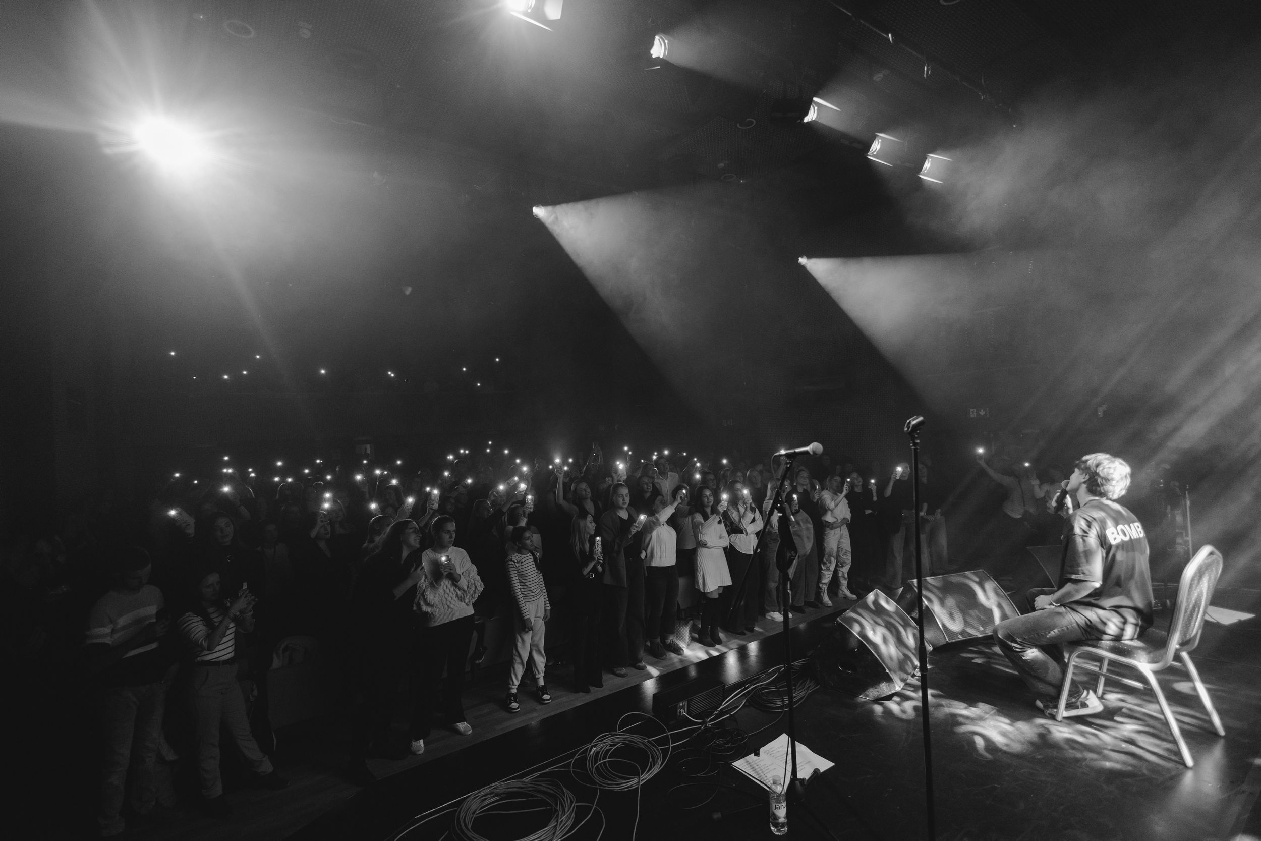 Black and white concert photos showing silhouettes of performers and audience under dramatic stage lighting.