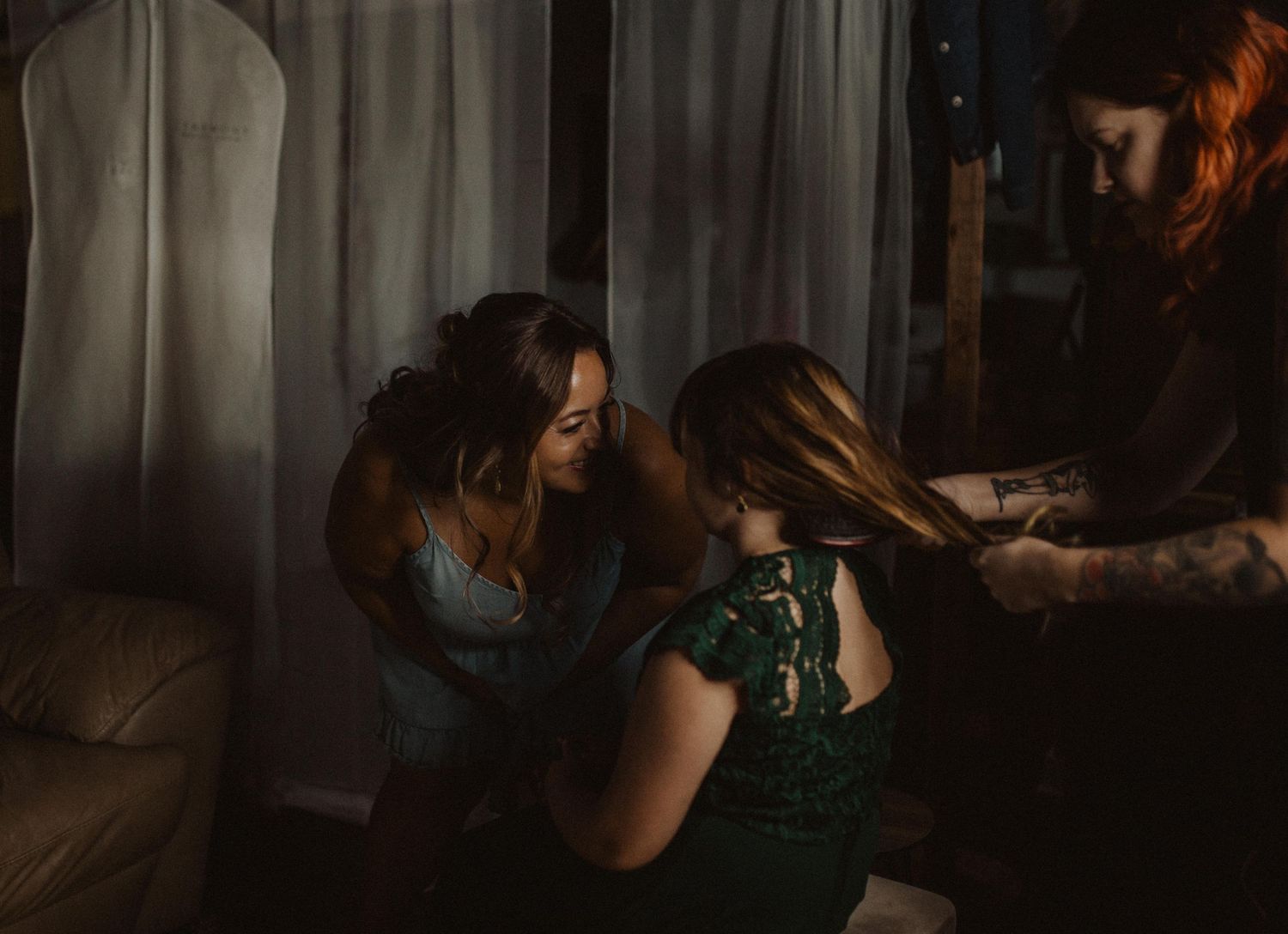 Intimate getting ready moment captured in warm, moody lighting.