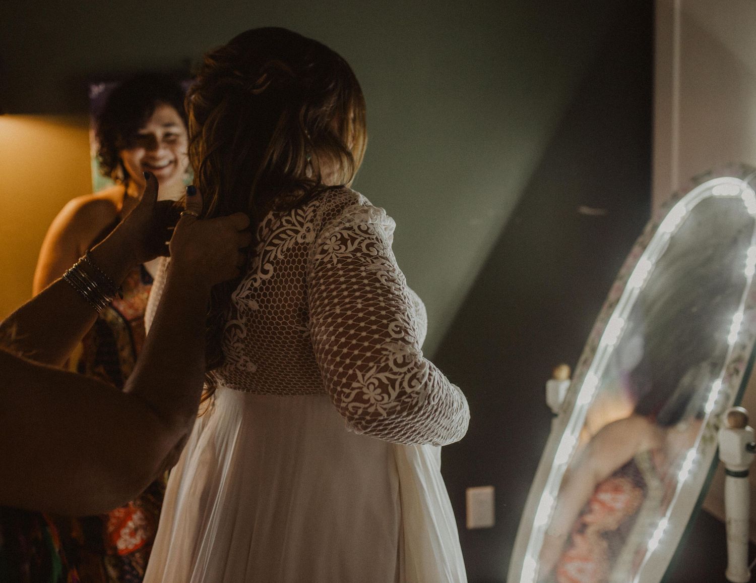 Wedding party getting ready in a dimly lit room with atmospheric lighting and elegant decor.