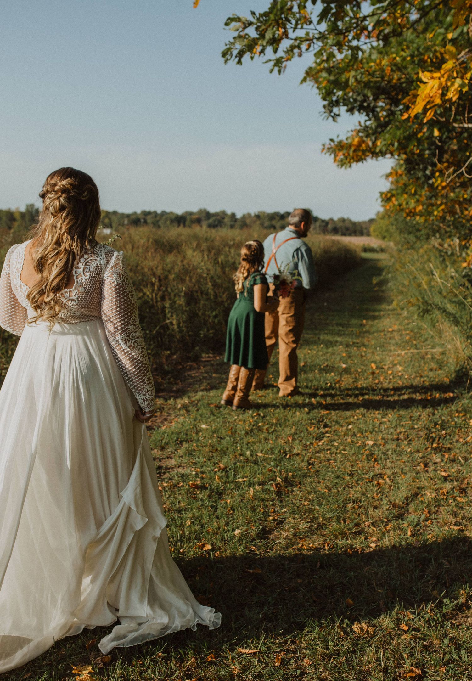 Elegant white wedding dress billowing in the wind during an outdoor autumn photoshoot.