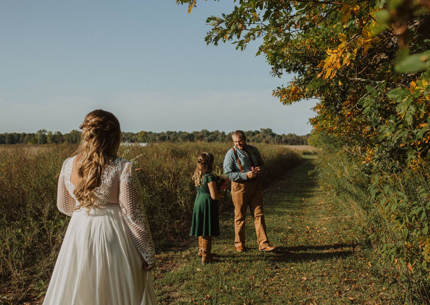 Autumn wedding scene in an orchard with trees and natural lighting.