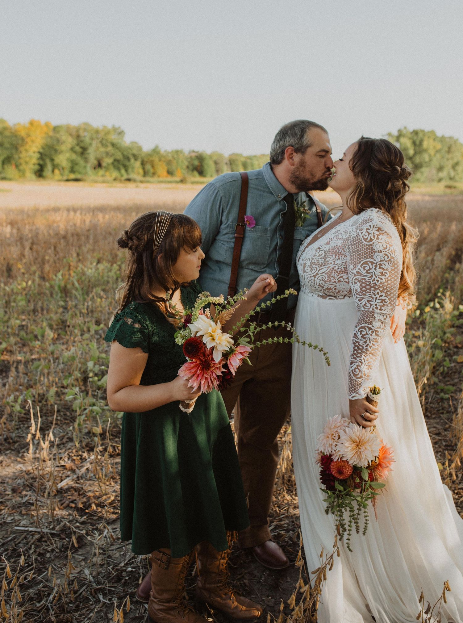 Wedding party celebrates in a field with autumn flowers and natural lighting.