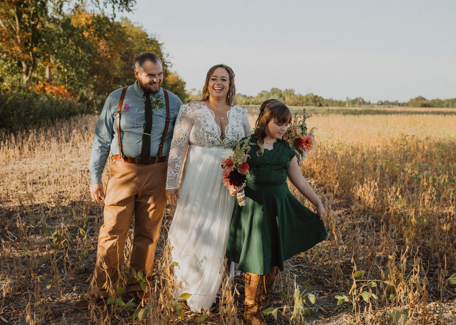 Wedding party poses in a golden field during sunset with natural fall colors.