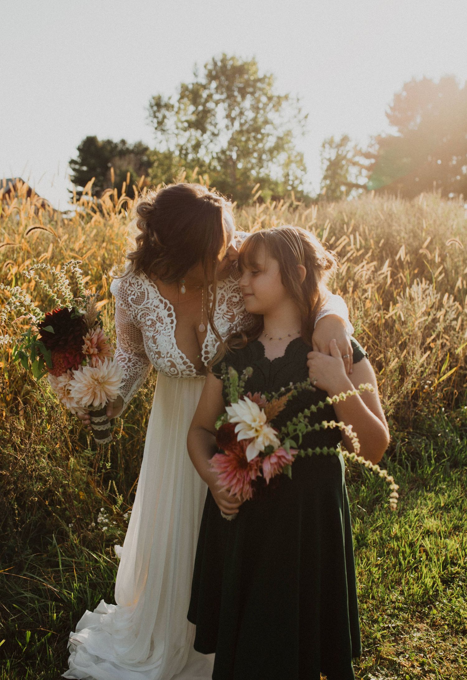 Intimate wedding moments shared in a field during golden hour with floral arrangements.