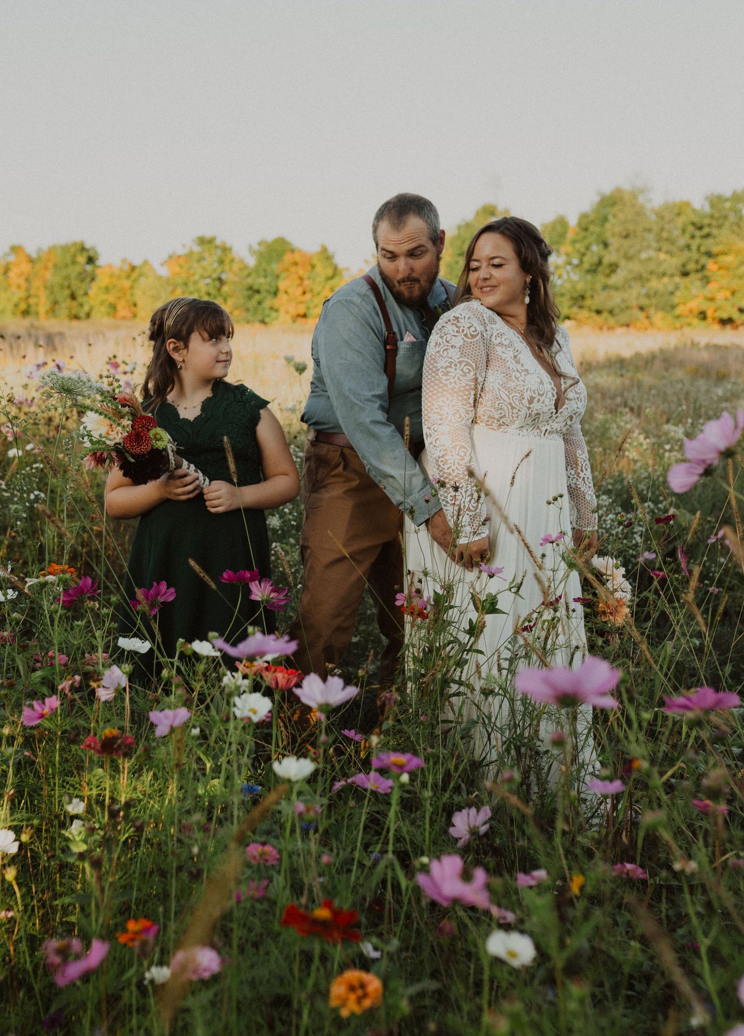 Candid photography session in a field of pink and white cosmos flowers during golden hour.