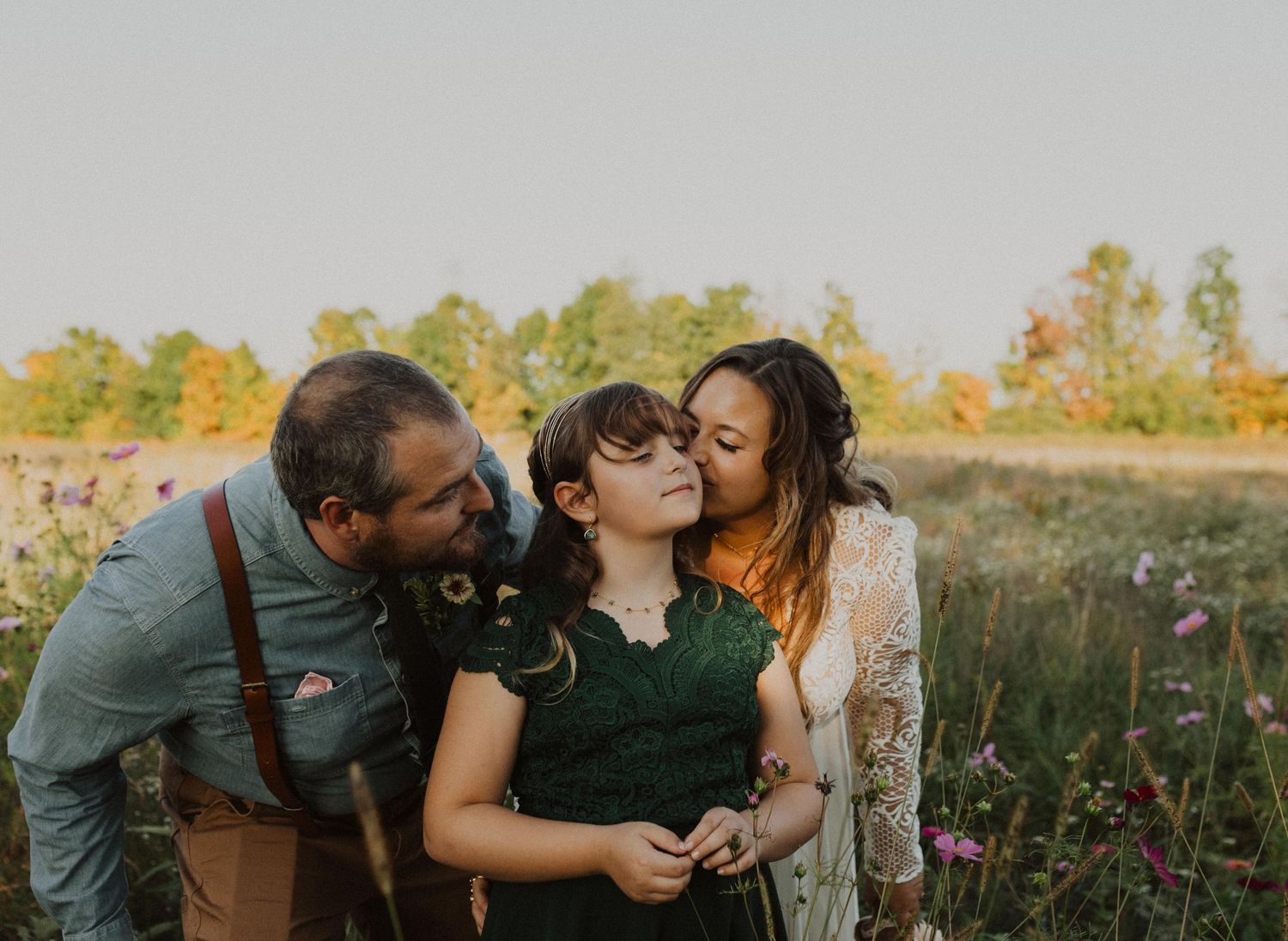 Friends share joyful moments together among blooming wildflowers at sunset.