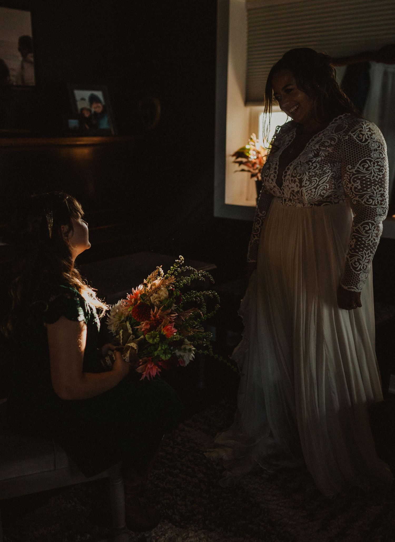 Dark and moody indoor scene with wedding preparations and floral arrangements.