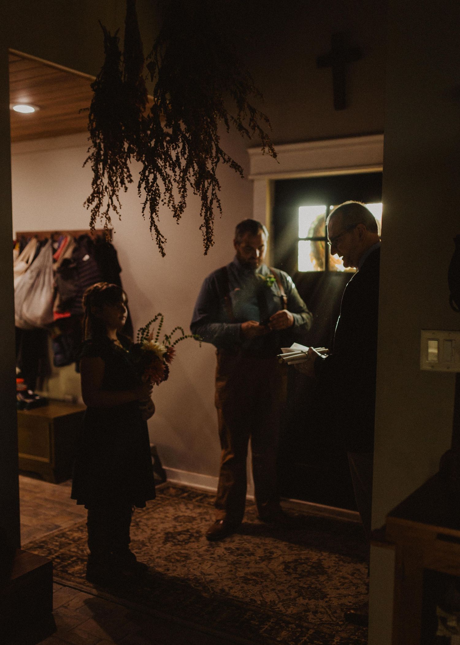 People gather in a dimly lit room with ambient lighting creating atmospheric shadows.