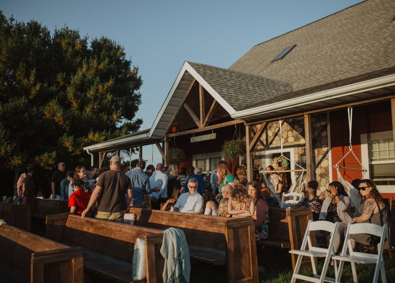 Rustic barn wedding venue exterior with white chairs set up for ceremony.