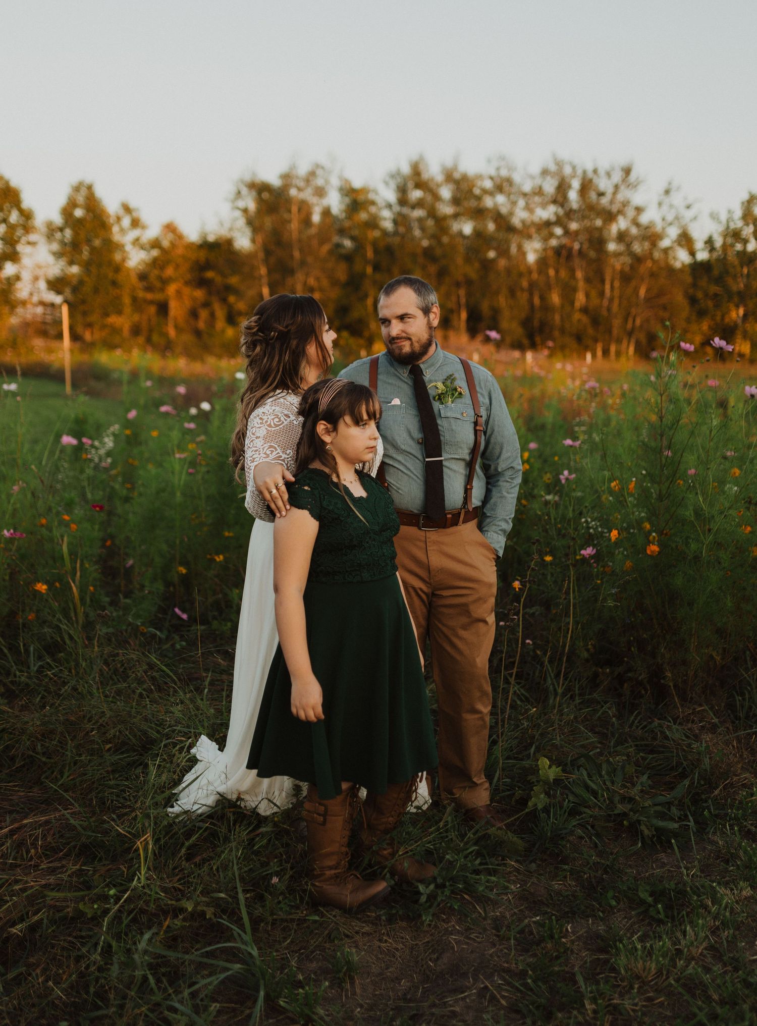 Wedding party poses in wildflower field during golden hour photography session.