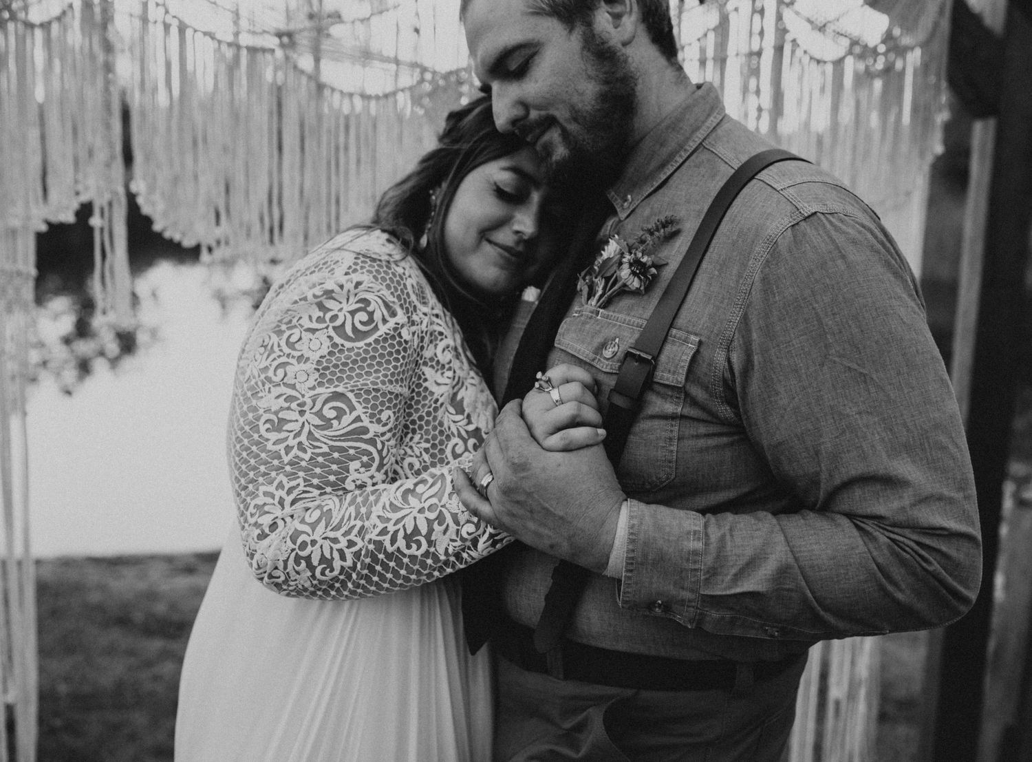 Black and white romantic wedding portraits under decorated pergola.