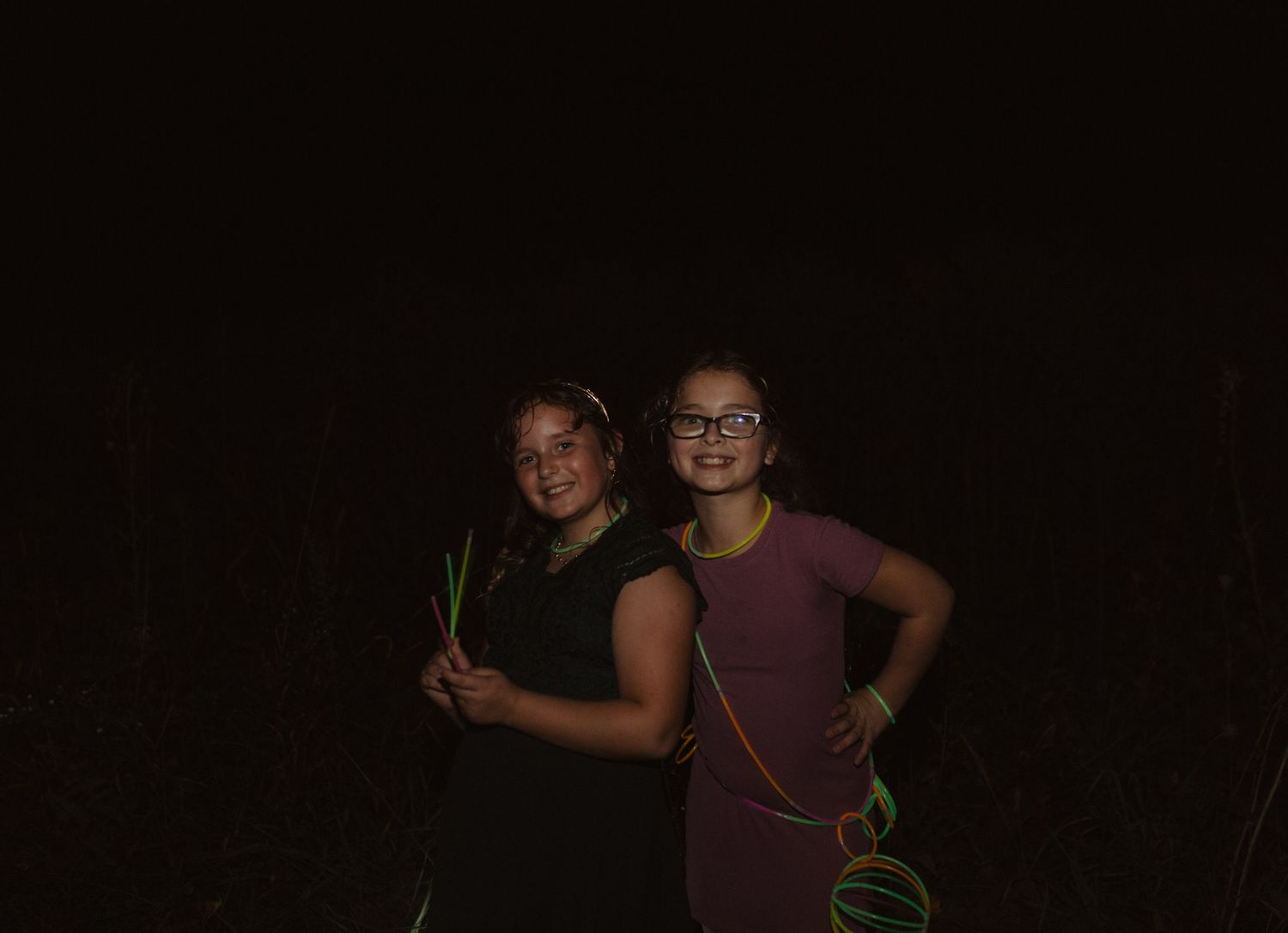 Guests celebrate and pose for photos during a nighttime outdoor party.