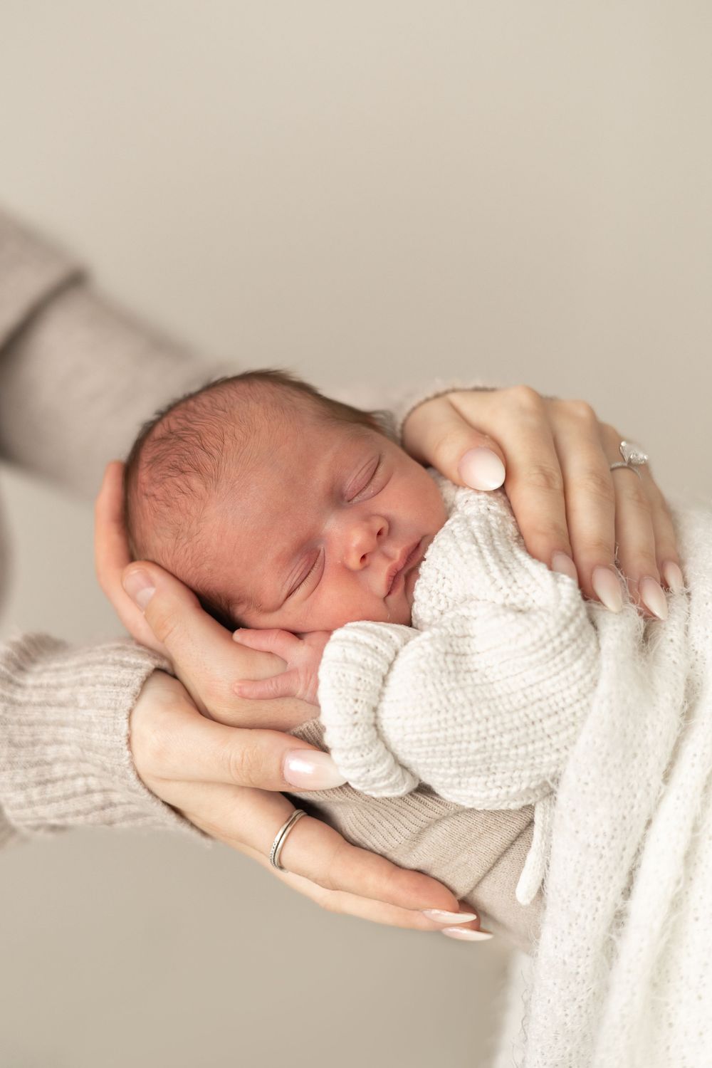 Newborn baby sleeping peacefully in mother's gentle hands, natural newborn photography Nottingham NG16
