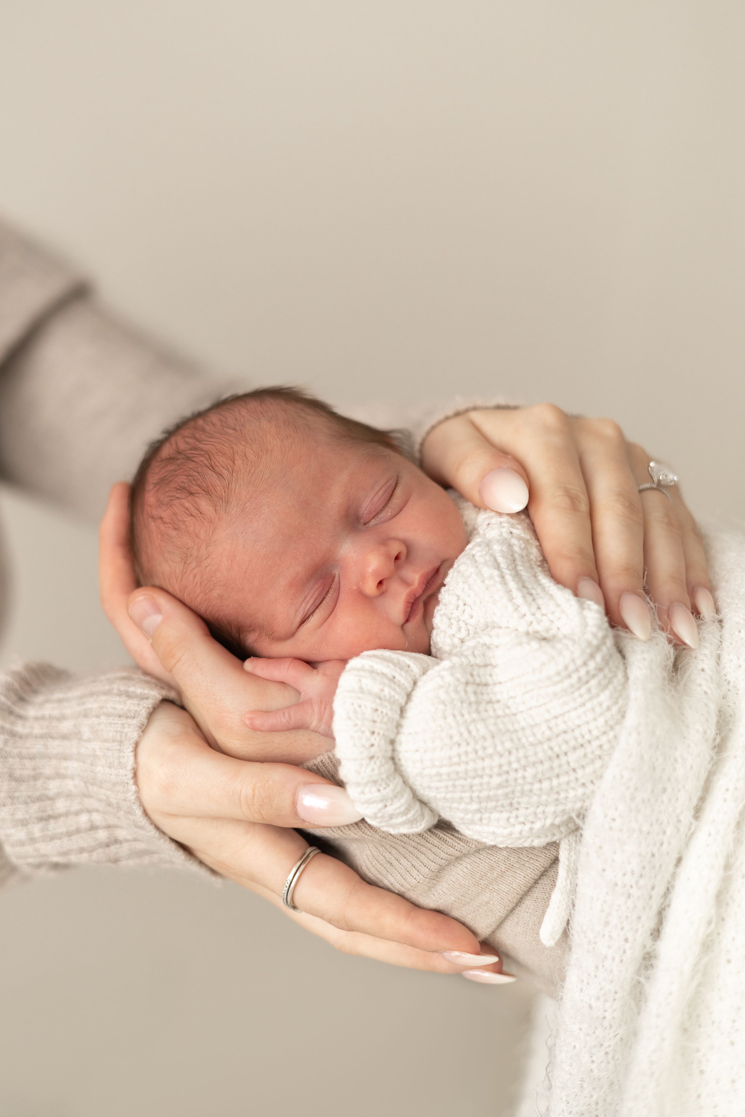 Newborn baby sleeping peacefully in mother's gentle hands, natural newborn photography Nottingham NG16