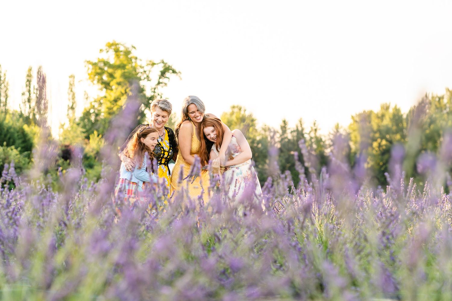 Three generation of women play together in a field of lavender at JB Family Growers in Woodinville.