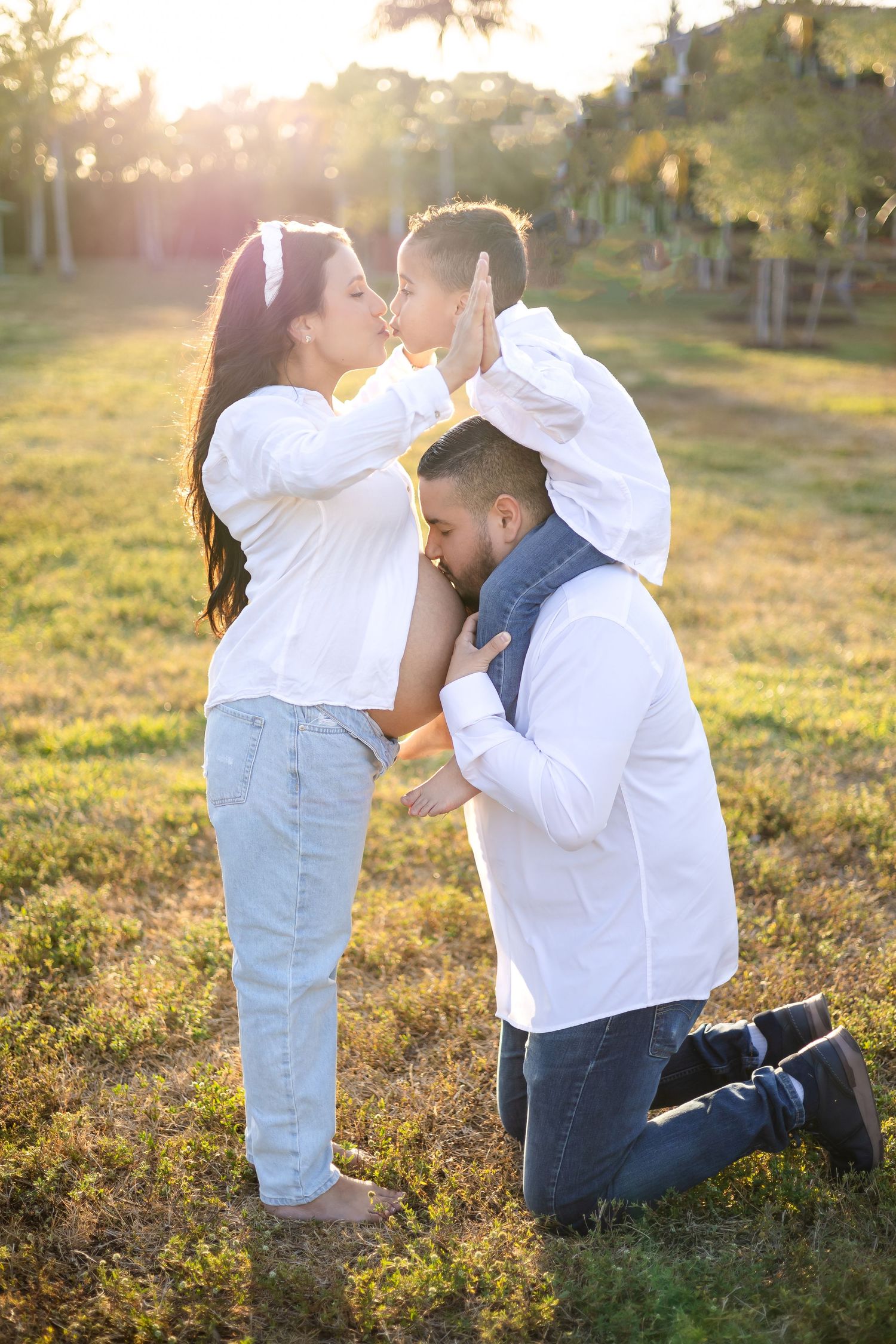 A tender family moment captured during sunset in an outdoor setting.