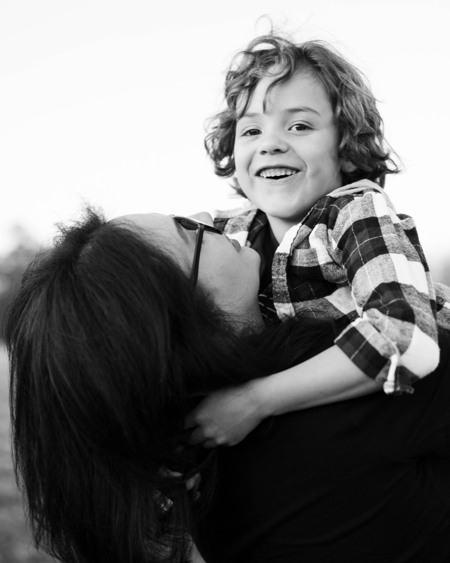 Black and white candid series showing joyful expressions and laughter during a family photo session.