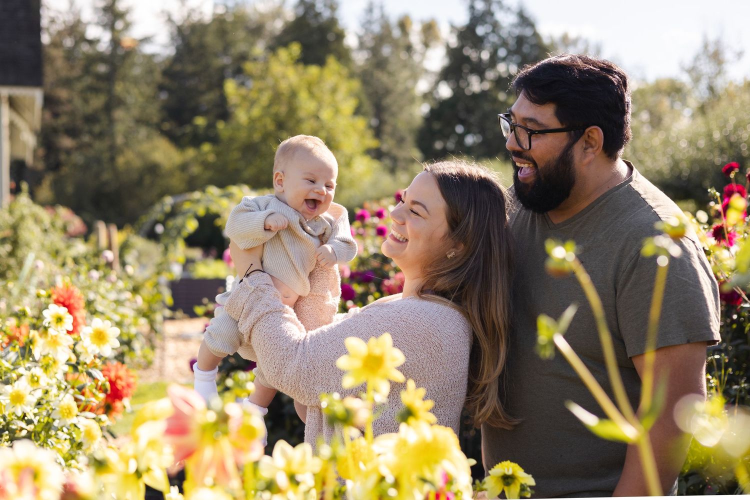 Winter maternity photo shoot with snow-capped mountains and evergreen trees in background.