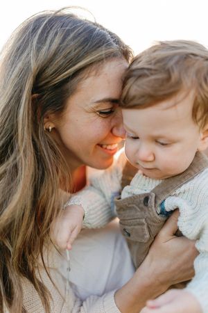 Close-up shots of tender family moments showing affection and bonding in warm sunlight.