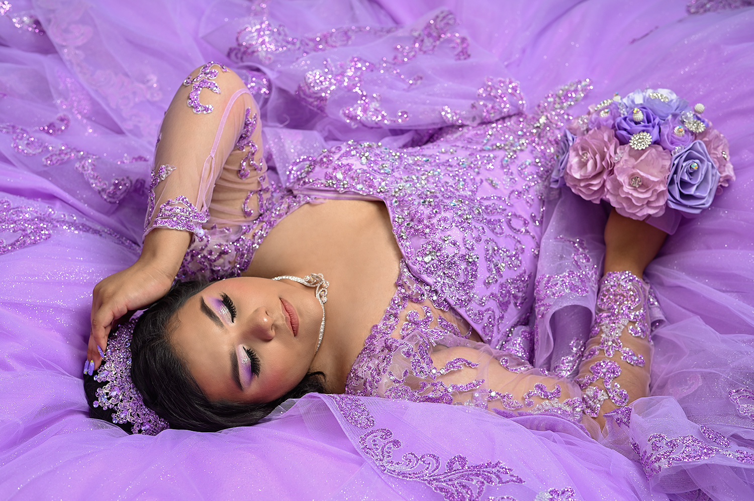 Artistic pose in a lavender tulle gown with beaded bodice and floral bouquet.
