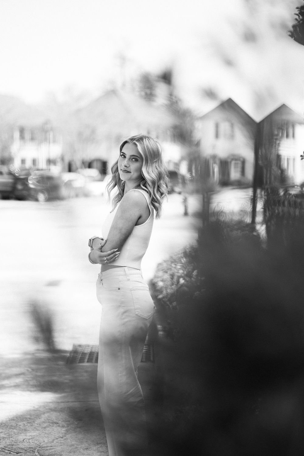Black and white portrait of a young blonde woman in jeans posing outdoors in a downtown business