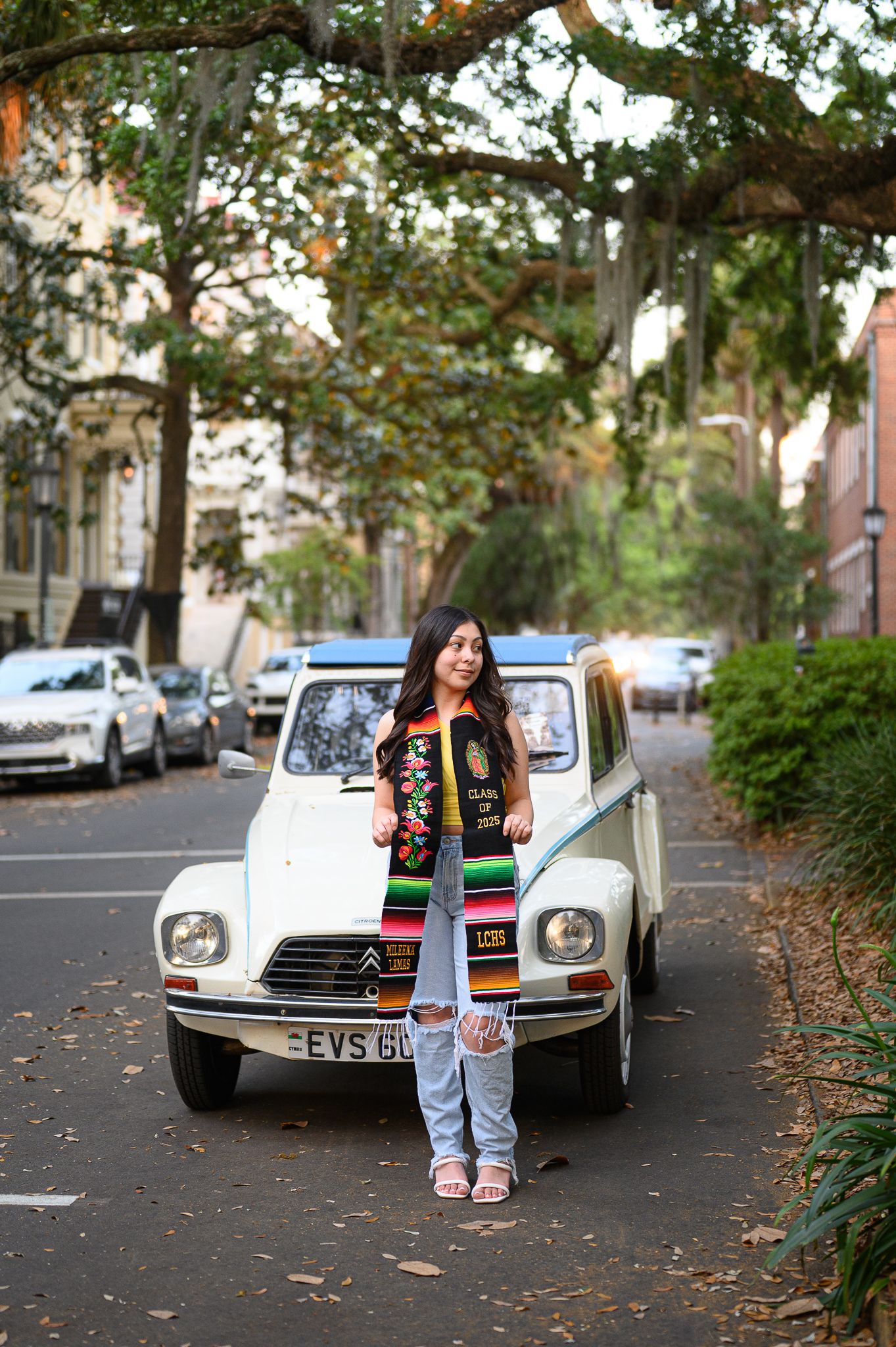 A vintage Citroen DS car parked on a tree-lined street during autumn with fallen leaves on the ground.