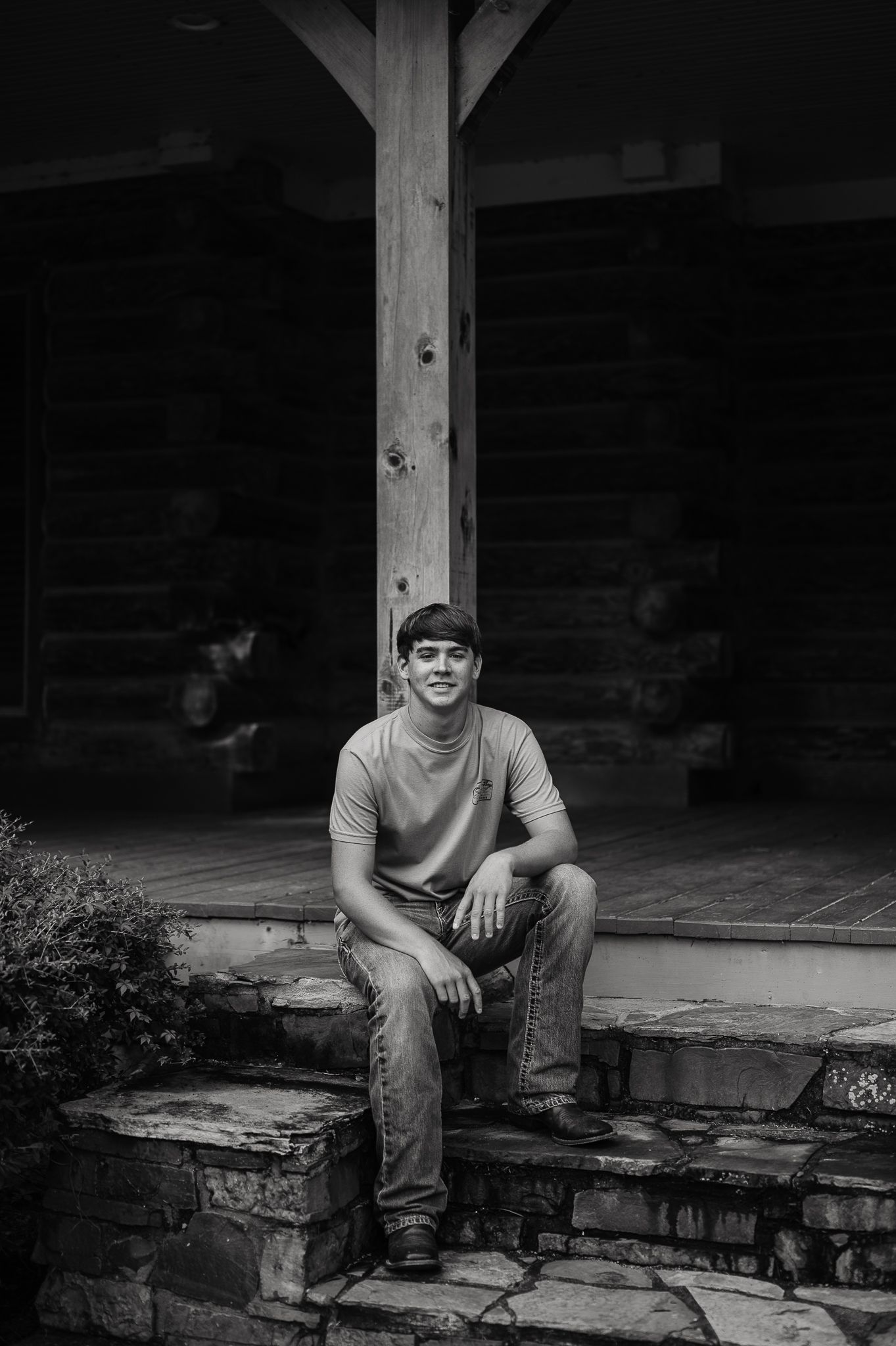 Black and white photo series showing someone sitting on stone steps in front of a rustic wooden structure.