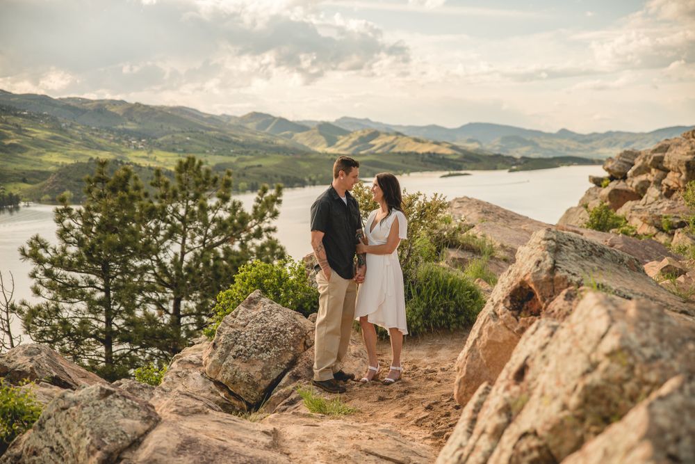 Couple shares intimate moment overlooking scenic mountain lake vista.
