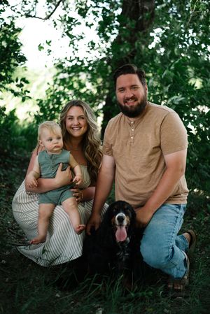 Family sitting together on grass enjoying casual outdoor moments in summer.