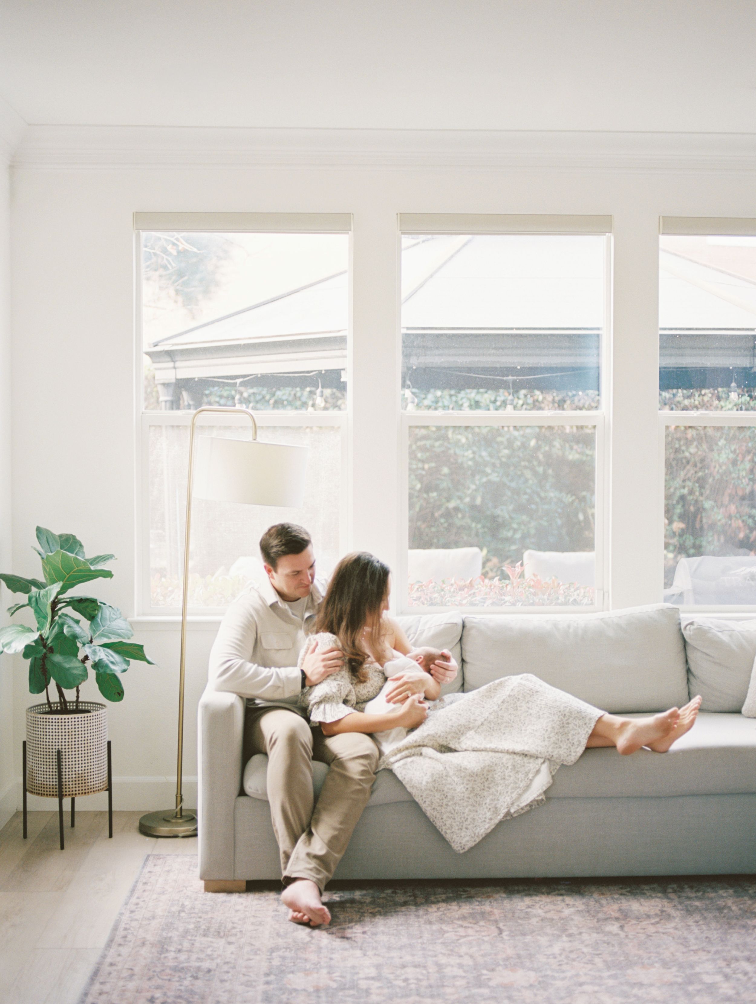 A series of four lifestyle photos showing people relaxing on a white sofa in a bright, modern living room with large windows.