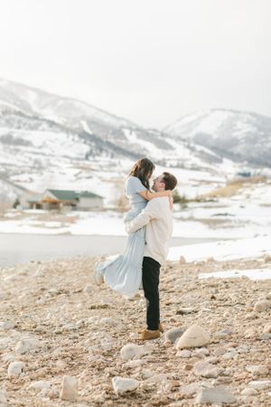 Fiancé picking up his soon to be bride during a frozen engagement session at Deer Lake Utah by Chelsee Rawe