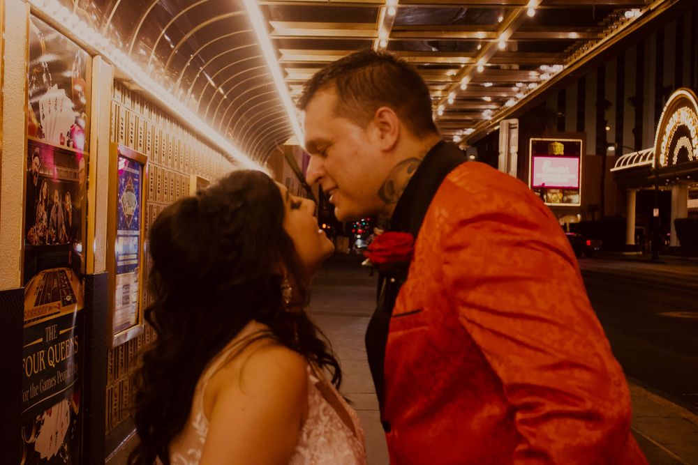 Bride and groom sharing an intimate moment under glowing marquee lights in Las Vegas.