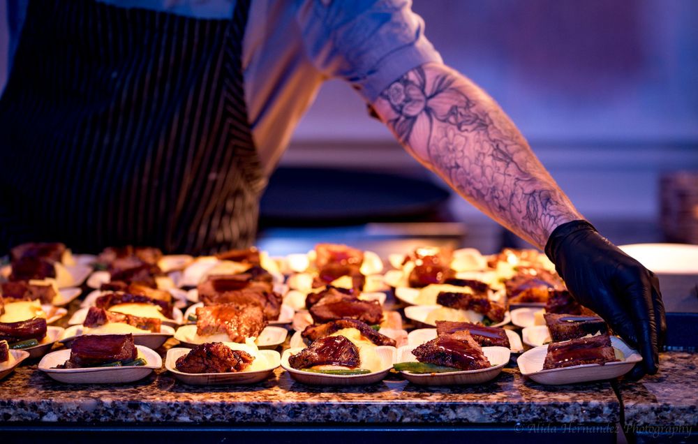 professional food photography of a man's tattooed arm at Reliaquest Bowl gala 2024