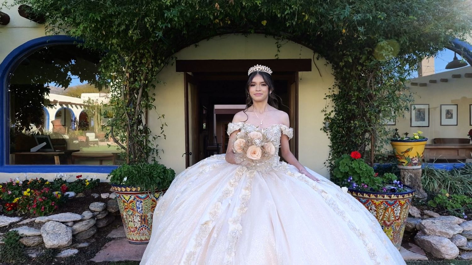 Ornate white ball gown dress photographed in front of ivy-covered entrance.