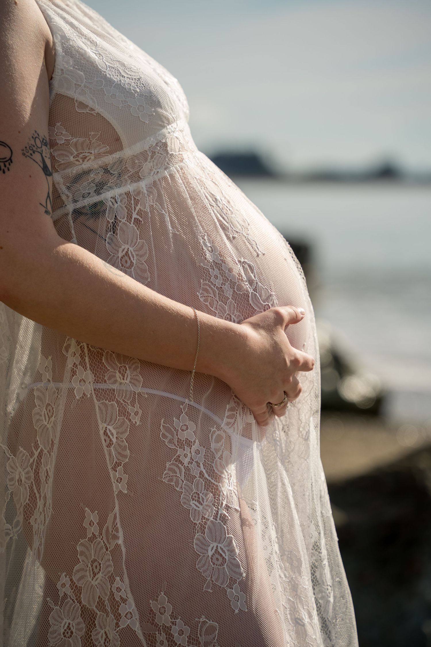 Pregnant mum portrait in lace gown at beach