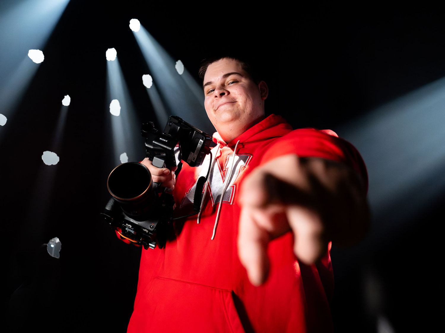 Picture of Mitchell Brandt holding a camera and pointing at the camera