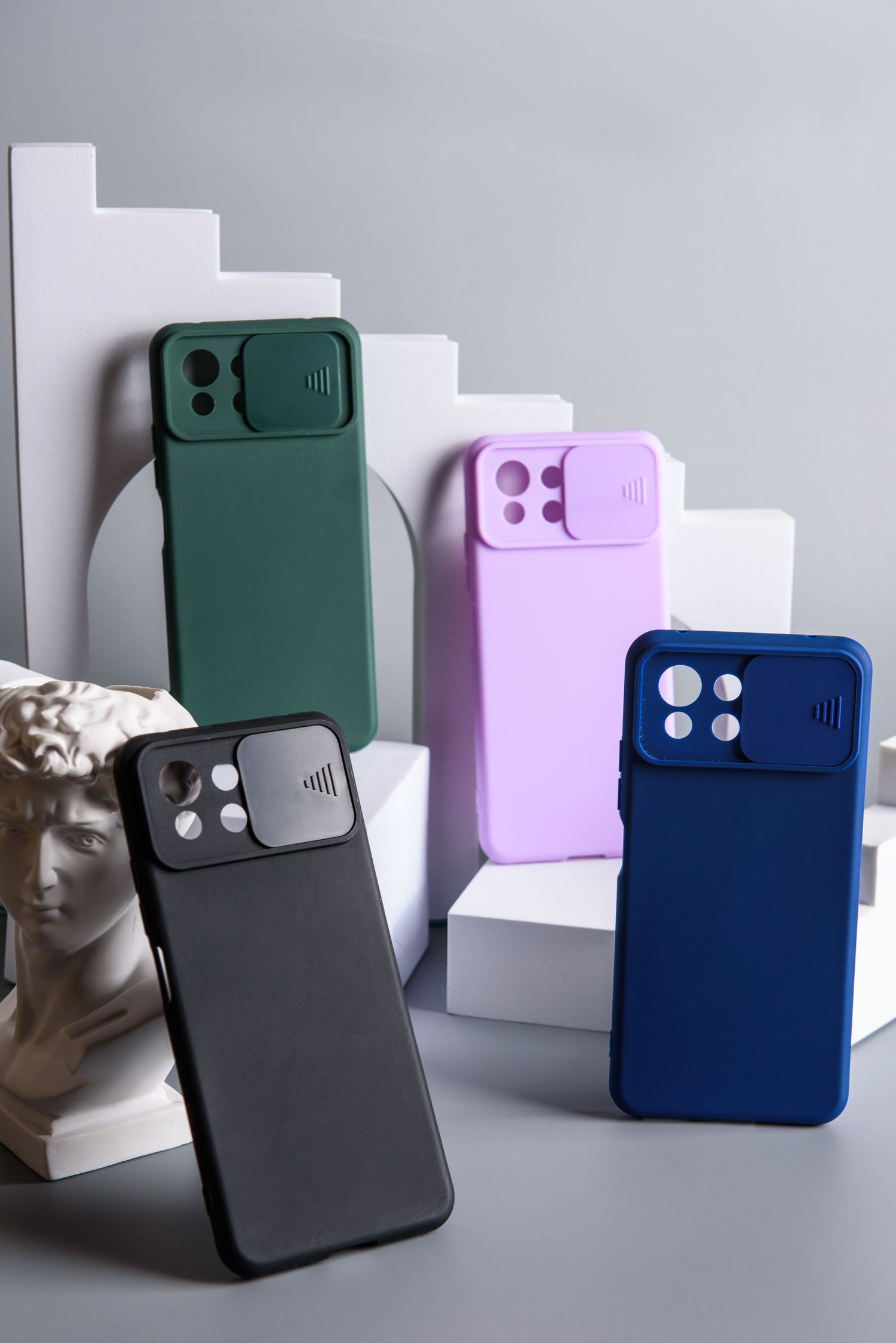 Collection of phone cases in green, purple, navy and black with camera lens covers.