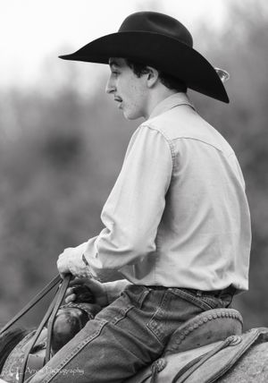 Black and white profile of cowboy in western hat riding horseback.