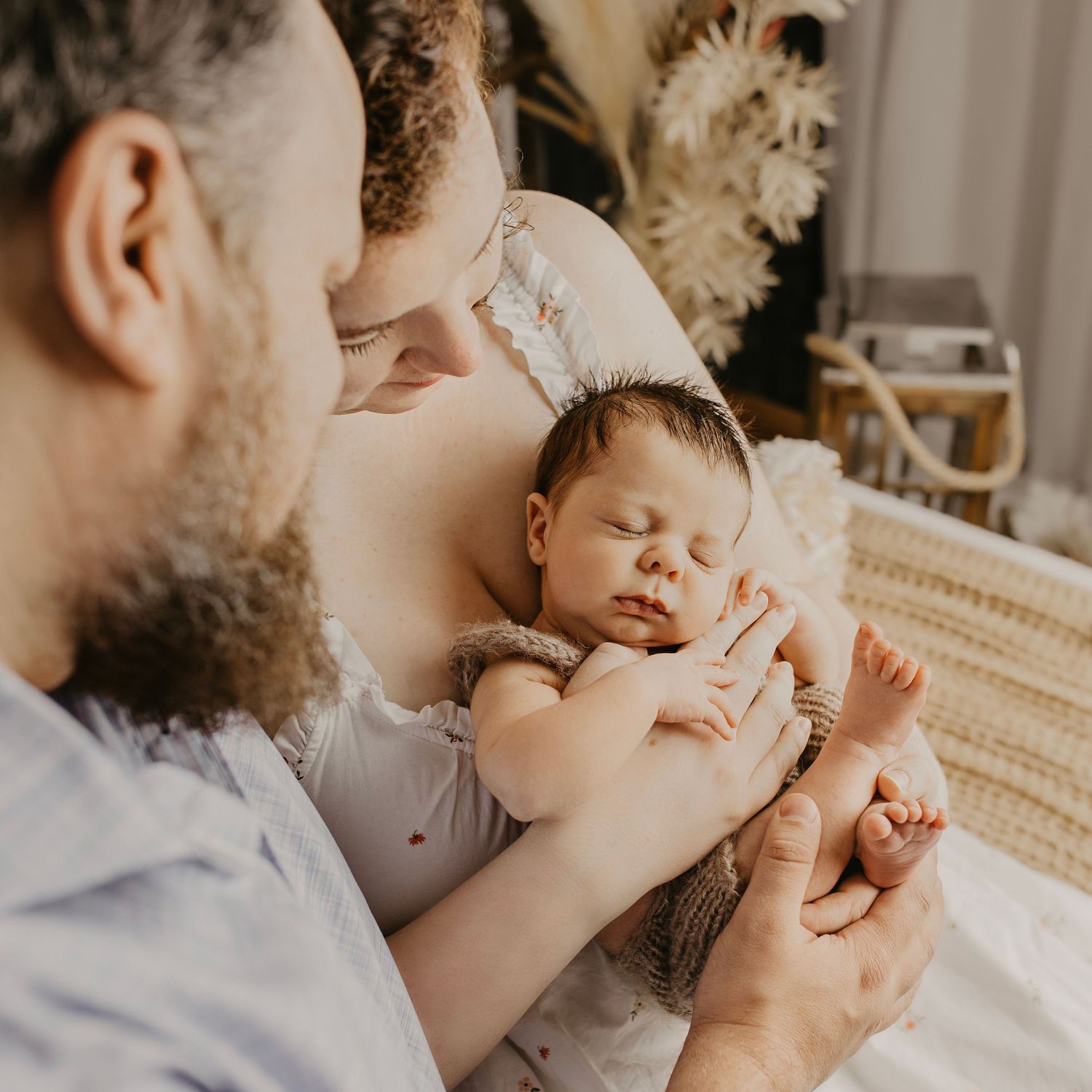 Parent giving affectionate kisses to baby in a tender moment captured in a series of intimate photographs. Ottawa lifestyle bohemian decor.