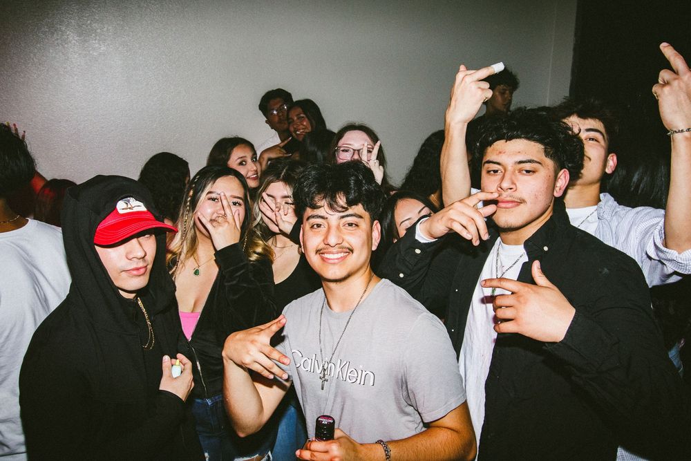 Group of young people smiling and celebrating together at an indoor party.