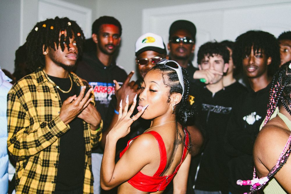 Group of young people posing and having fun at an indoor party with colorful outfits.
